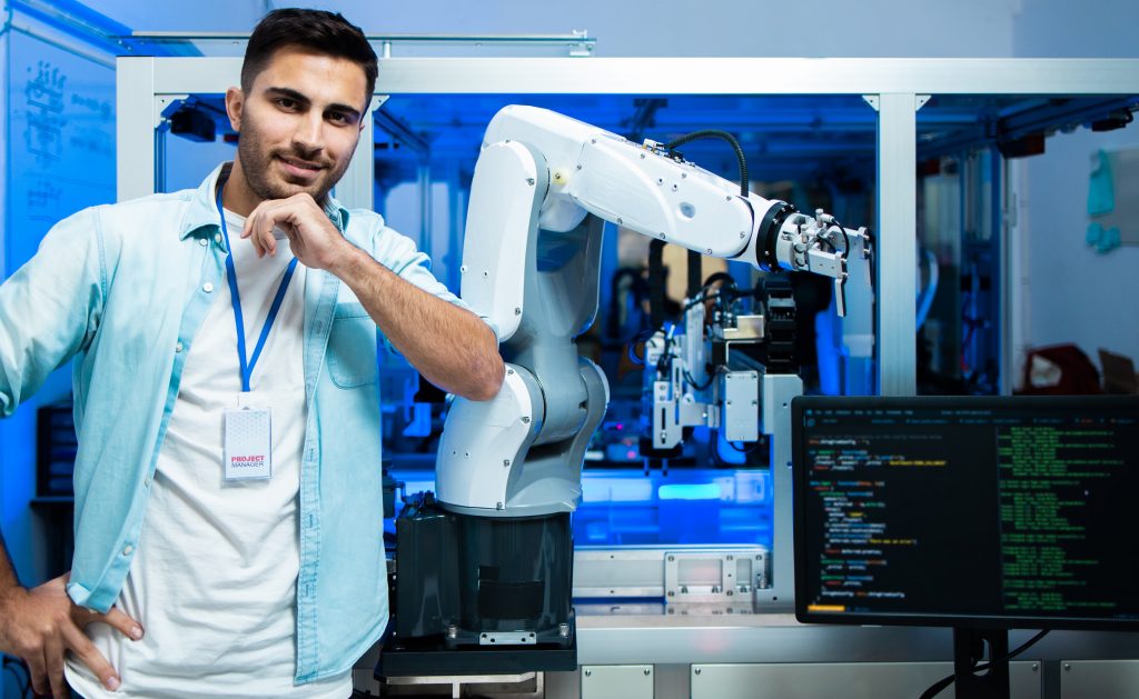 Caucasian Engineers Maintenance Robot Arm at Lab. they are in a High Tech Research Laboratory with Modern Equipment. Professional Japanese Development Engineer Testing an Artificial Intelligent. Robotik Weiterbildung mit Förderung über Bildungsgutschein